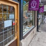 Entrén till Thörnströms Vintage Jewellery i Linköping med skyltfönster fyllt av antika smycken och lila flaggor med butikens logotyp
