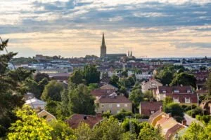 Utsikt från Koberget över Linköpings villakvarter och stadssiluett med Linköpings domkyrkas höga torn mot en dramatisk himmel