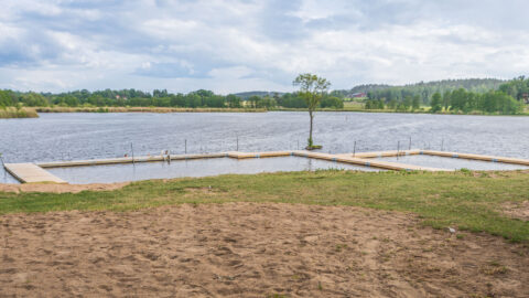 Sandstranden och den u-formade bryggan vid Sturefors badplats