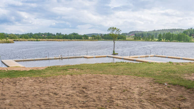 Sandstranden och den u-formade bryggan vid Sturefors badplats