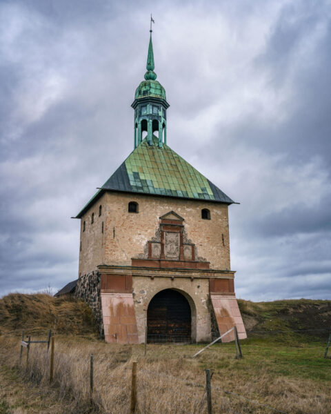 Johannisborgs slottsruin i Norrköping med sitt karaktäristiska porttorn, ärggrönt koppartak och lanternin under mulen himmel.