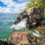 Trappan ner till den gamla hamnen i Stocklycke, Omberg, vattnet är smaragdgrönt och höga vågor slår upp mot klipporna