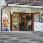 Entrén till Göta Glass i Söderköping med en stor glassfigur vid trappan och skylt som erbjuder italiensk egentillverkad glass, slush, mjukglass och kaffe.