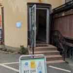 Entré till Björnes Magasin i Kisa med öppen dörr, trappa upp och gatupratare med Vikingsoda-reklam "Byt din patron här!"