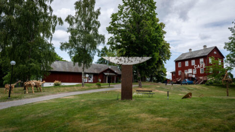 Dalslands konstmuseum med skulpturpark, röda träbyggnader och Café Bonaparte, omgivet av björkar och grönska i Upperud