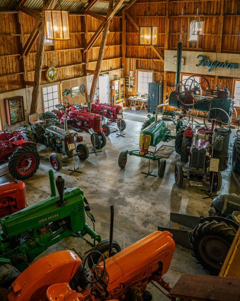 Traktormuseum i stor lada med vintage-traktorer från John Deere, Ferguson och Farmall, nära Håverud i Dalsland