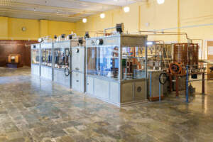 Historisk radiosändarutrustning utställd i en stor hall med gula väggar på Sveriges Rundradiomuseum i Motala