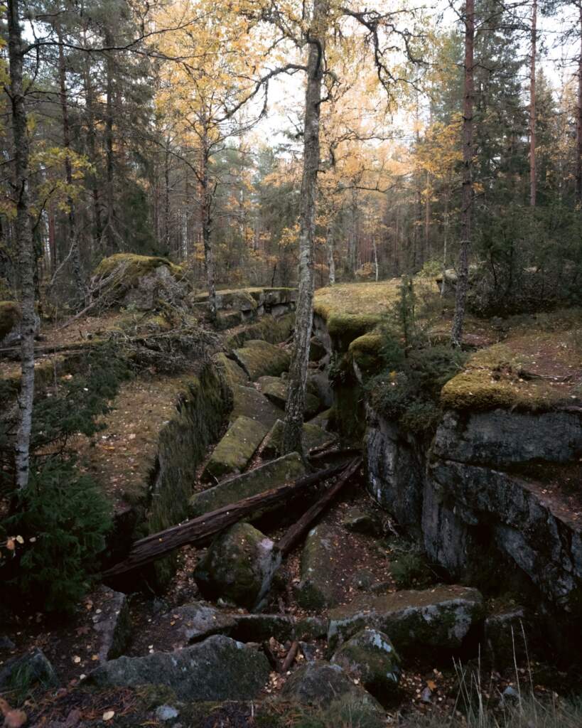 Mosstäckta klippformationer och urbergssprickor i höstlig skog vid Trollegater naturreservat i Kinda kommun, Östergötland
