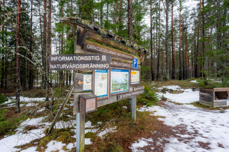 Informationsskylt vid entrén till Orrkojgölarnas naturreservat med vägvisare