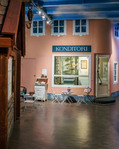 Återskapad konditorifasad i rosa med skyltfönster och caféstolar på Norrköpings stadsmuseum i Industrilandskapet