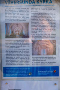 Informationsskylt om Väversunda kyrka med text om kyrkans historia från 1100-talet, kalkmålningar och bilder på interiören