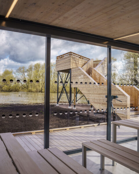 Modern värmestuga med träbänkar och utsikt mot fågeltornet i trä vid Stångåmynningen, där Stångån möter Roxen i Linköping