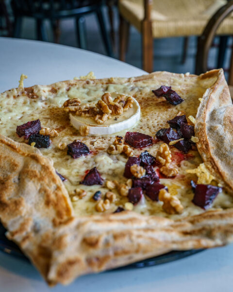 Fransk galette med chèvre, rödbetsbitar och valnötter serverad på tallrik på crêperiet Oui Albacken i Mjölby kommun