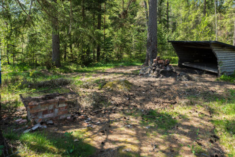 Vindskydd och enkel grillplats med tegelmurad eldstad i en solig glänta i Magnehult naturreservat, Finspång