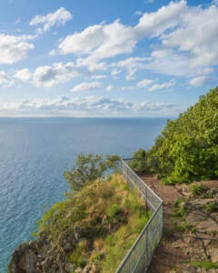 Utsiktsplats vid Västra väggar på Omberg med räcke längs klippkanten och vidsträckt vy över Vättern en sommardag