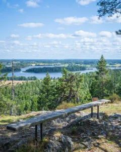 Utsikten från Bore Kulle med sjö och skog och en bänk i förgrunden.