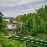 Gröna akvedukten i Håverud med bilbron ovanför, omgiven av frodig grönska och klippor längs Dalslands kanal.