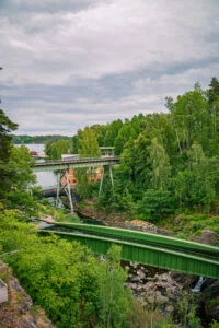Gröna akvedukten i Håverud med bilbron ovanför, omgiven av frodig grönska och klippor längs Dalslands kanal.
