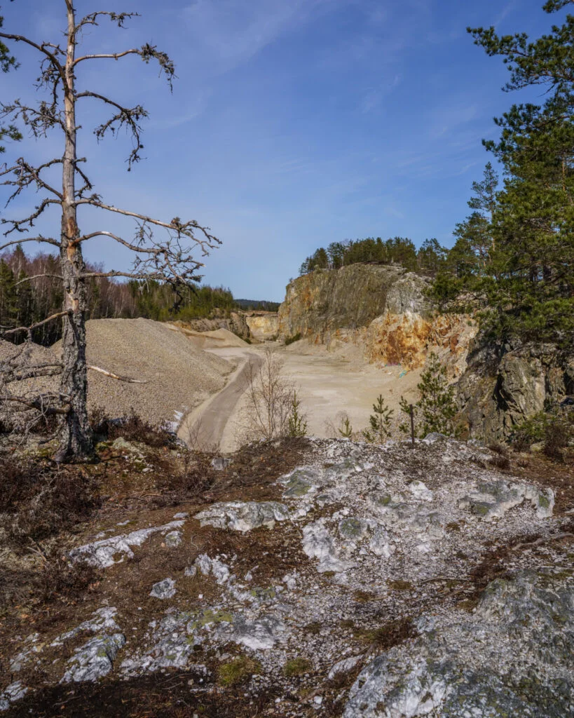 Stenbrott med bergväggar och grushögar omgivet av tallskog vid Bläsen nära Fröskog i Dalsland
