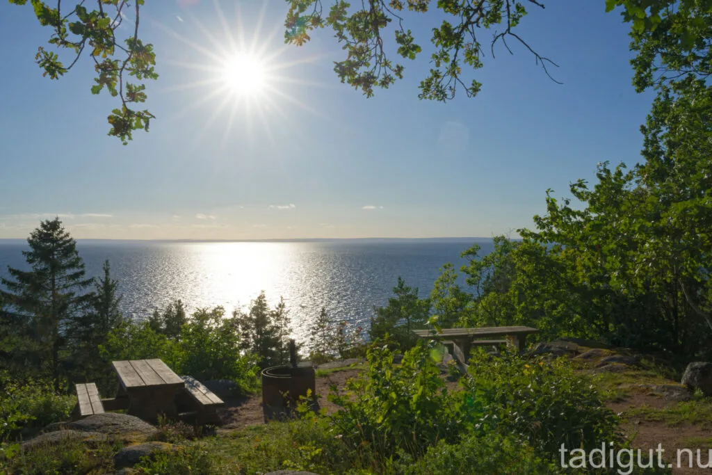 Utsiktsplats vid Kråkeryd med bänk, grillplats och solglittrande vy över Vättern, omgiven av grönska