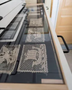 Handknyplade spetsprover utställda i glasmonter på Vadstena Spetsmuseum i Gottfrid Larssongården, Östergötland