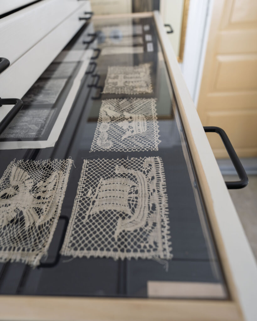 Handknyplade spetsprover utställda i glasmonter på Vadstena Spetsmuseum i Gottfrid Larssongården, Östergötland