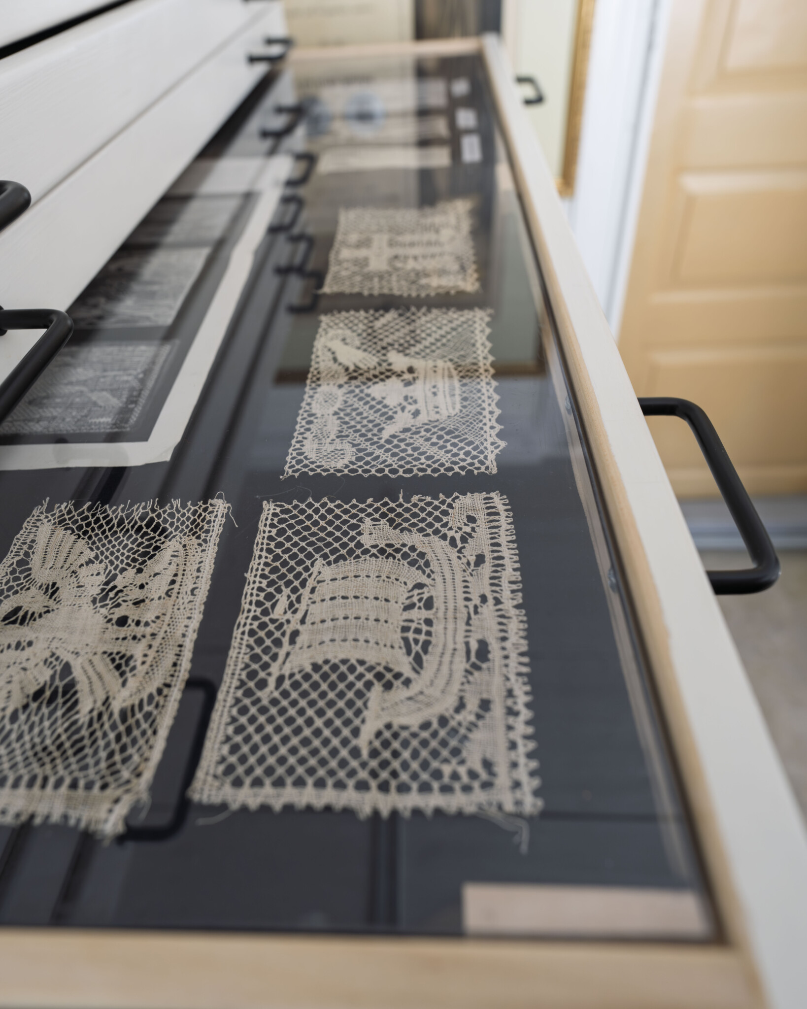 Handknyplade spetsprover utställda i glasmonter på Vadstena Spetsmuseum i Gottfrid Larssongården, Östergötland