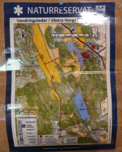 Informationskarta över vandringsleder i Västra Hargs naturreservat med teckenförklaring, sjön Aren och markerade stigar i Östergötland.