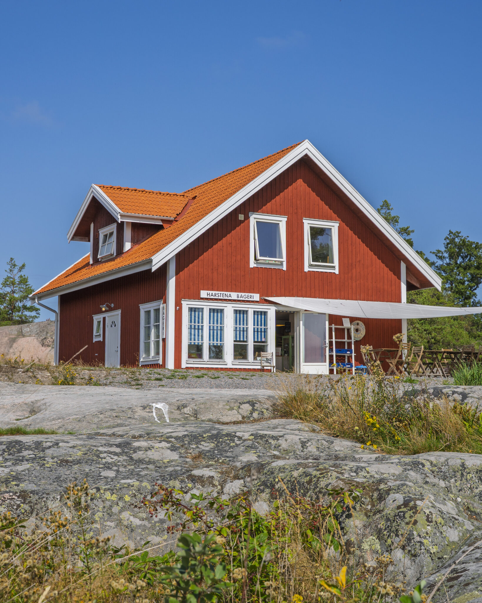 Harstena Bageri, ett rött trähus med vita knutar och tegeltak på klipporna på skärgårdsön Harstena i Östergötland.