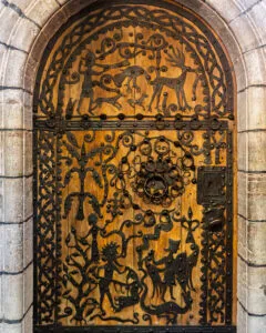 Rogslösadörren från 1275 med smidda järnornament på trä, föreställande djur och figurer, i Roglösa kyrkas romanska stenportal