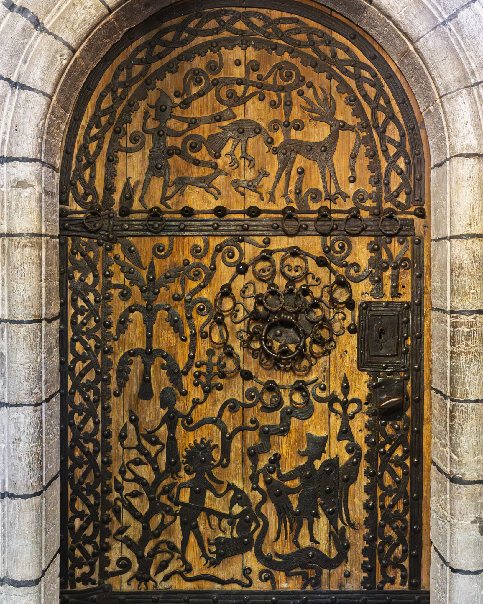 Rogslösadörren från 1275 med smidda järnornament på trä, föreställande djur och figurer, i Roglösa kyrkas romanska stenportal