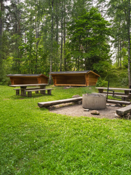 Rastplats med eldstad, träbänkar och vindskydd i grönskande skogsområde vid sjön Illern i Tranås kommun.