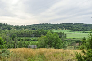 Utsikt över grönt odlingslandskap med lövträd, åkermark och skogsbeklädda kullar vid Abona i Tranås kommun.