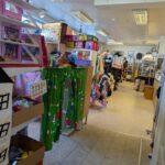 Interiör från Ture Lång's återbruk i Skänninge med hyllor fyllda av leksaker, textilier, kläder och prylar i en rymlig secondhandbutik